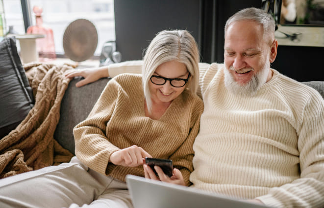 A couple looking at a cell phone in their home
